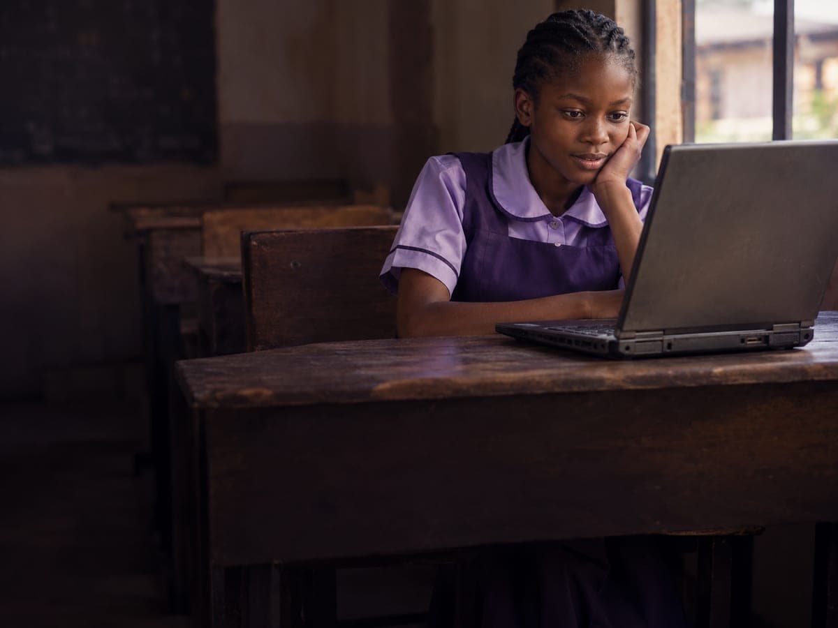 A girl looking at a laptop in a classroom